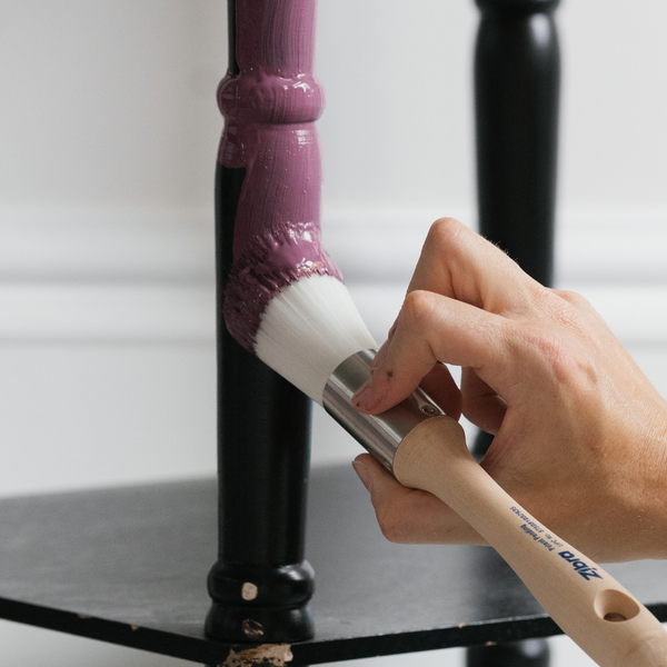 round brush painting a furniture leg