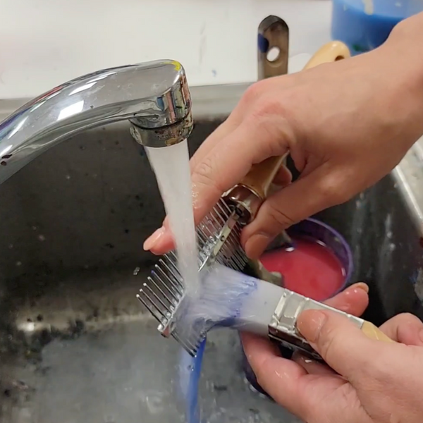 cleaning a paint brush with water and cleaning comb