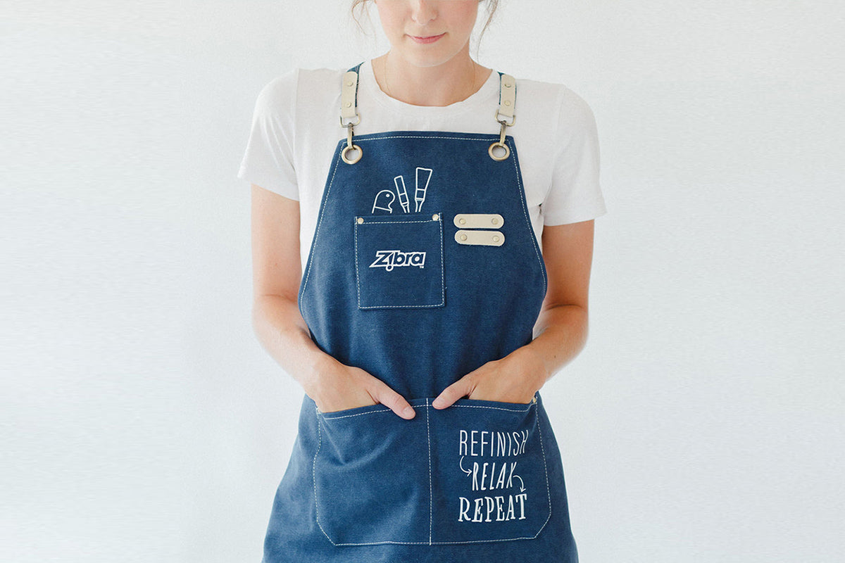 girl standing with painting apron on with brushes in pocket
